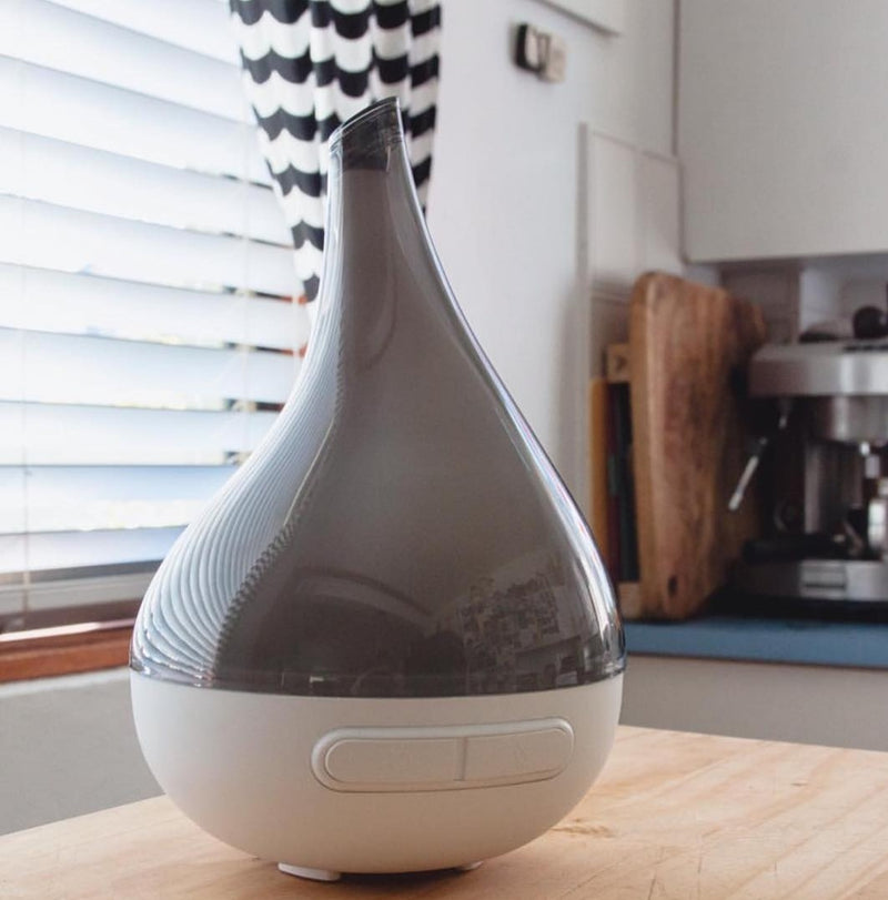 White and gray diffuser on a kitchen counter with blurred background