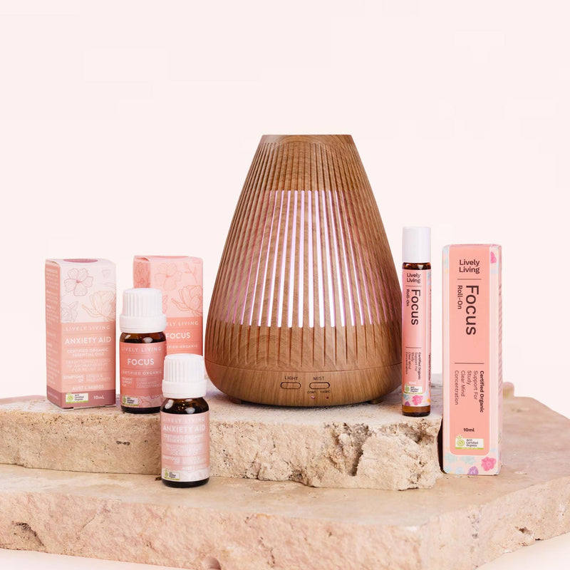 Aromatherapy products including diffusers and essential oils on a wooden surface with a white background. Lively Living