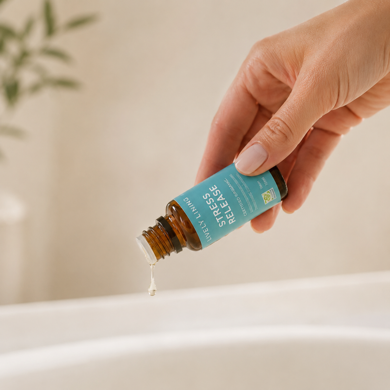 Hand holding a bottle of essential oil labeled 'Stress Release' with a droplet being released.