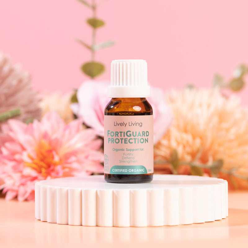 Lively Living FortiGuard Protection bottle on a white platform with flowers in the background