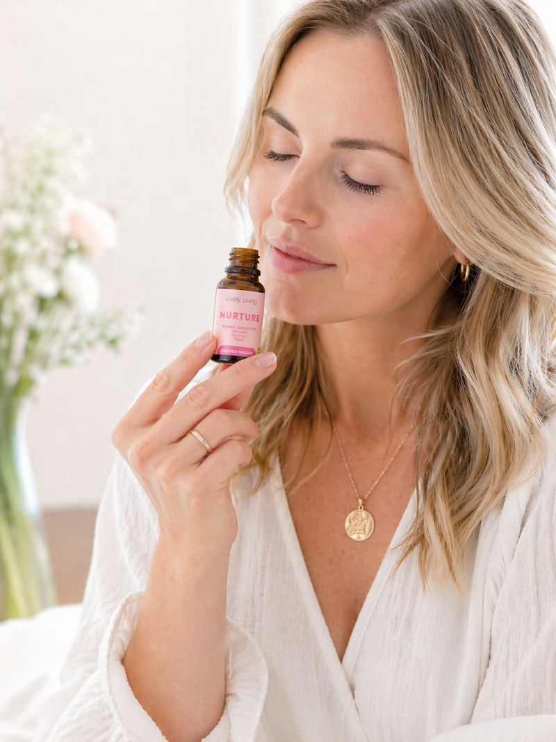 Woman holding a bottle of 'Nurturing' essential oil