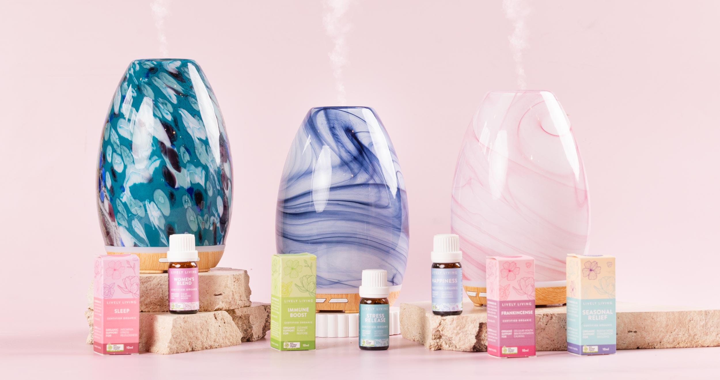 Lively Living glass diffusers misting beside certified organic essential oils