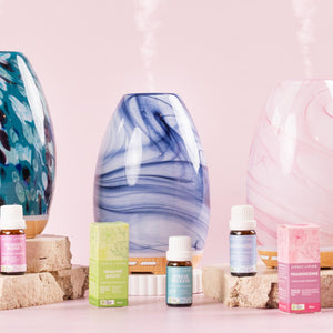 Lively Living glass diffusers misting beside certified organic essential oils