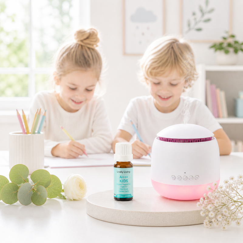 Two children sitting at a table with a diffuser and bottle of essential oil, surrounded by stationery and plants.