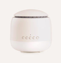 White diffuser with control buttons on a light beige background