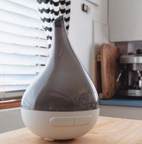 White and gray diffuser on a kitchen counter with blurred background