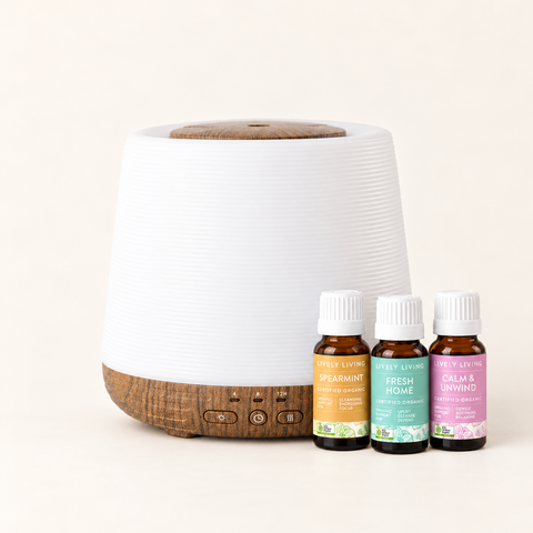Aroma-Home diffuser with a ribbed white body and wood-look base beside Lively Living Spearmint, Fresh Home and Calm & Unwind oils from the Home Essentials Trio