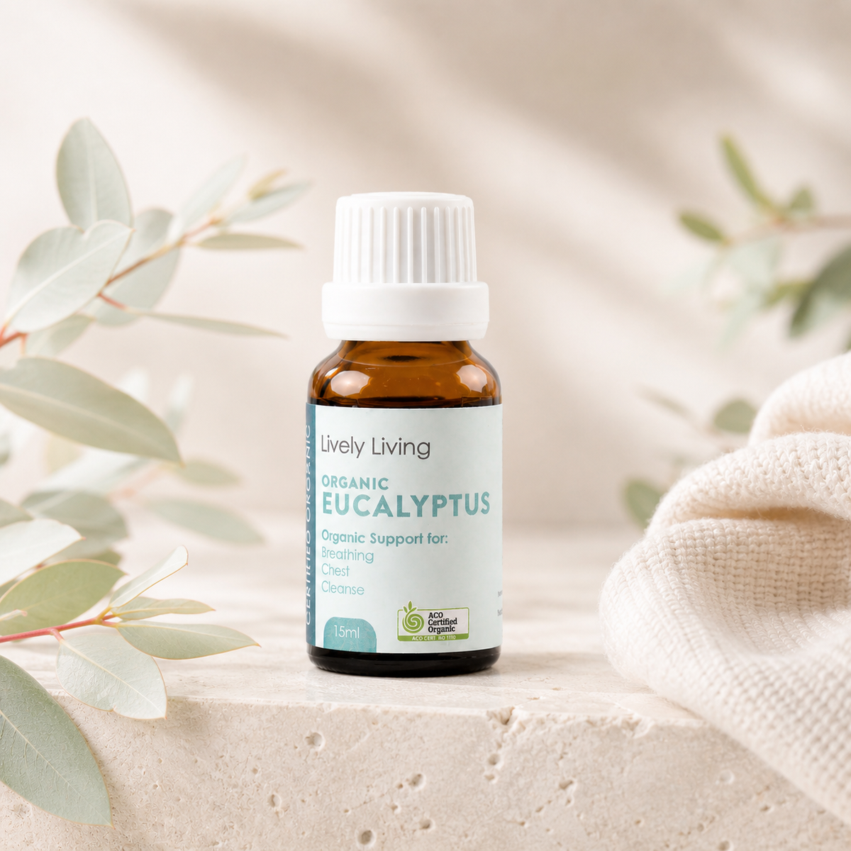 Bottle of Lively Living Organic Eucalyptus oil with eucalyptus leaves in the background