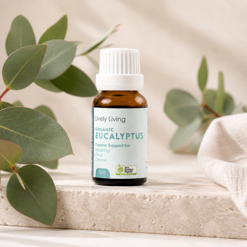 Bottle of Lively Living Organic Eucalyptus oil with eucalyptus leaves on a neutral background