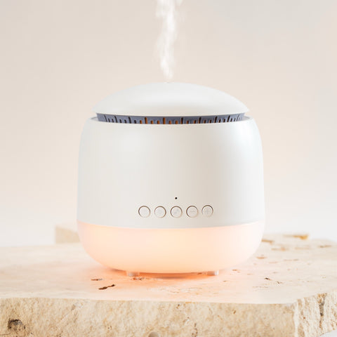 White diffuser emitting a soft glow on a light wooden surface