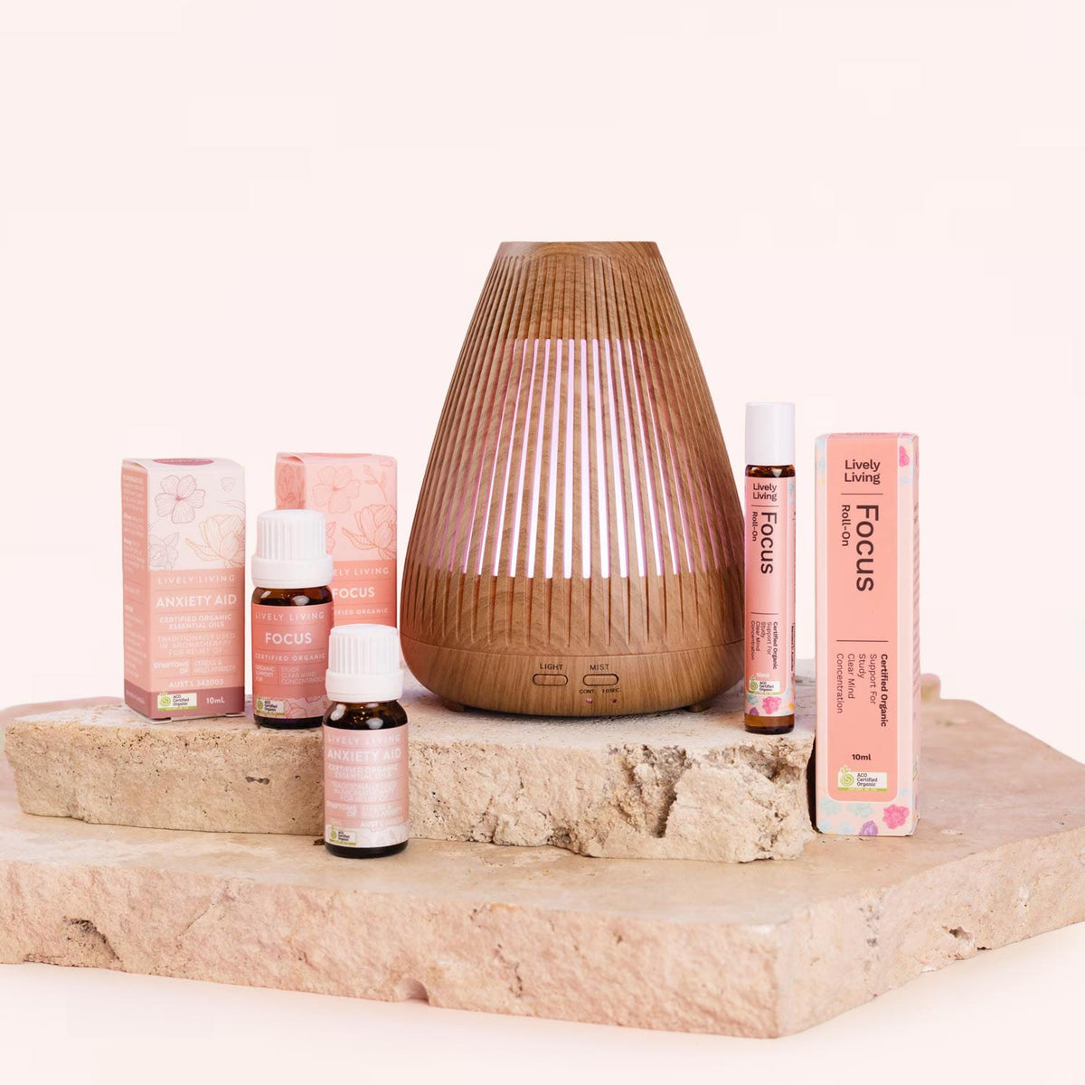 Aromatherapy products including diffusers and essential oils on a wooden surface with a white background. Lively Living 