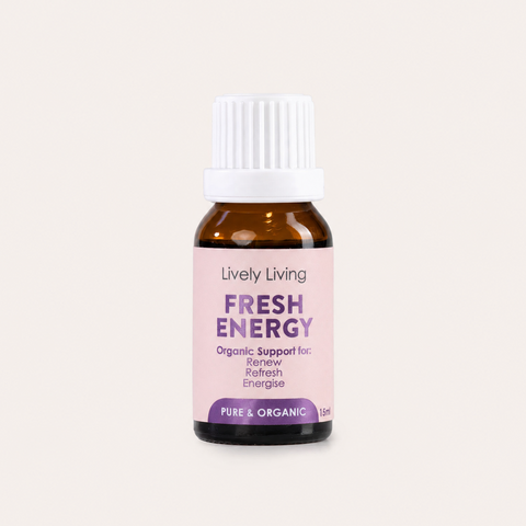 A small amber glass bottle with a white ribbed cap and a pale pink label reading 'Lively Living FRESH ENERGY' on a light warm-gray background.
