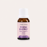 A small amber glass bottle with a white ribbed cap and a pale pink label reading 'Lively Living FRESH ENERGY' on a light warm-gray background.