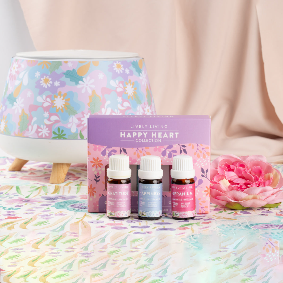 Happy Heart Collection oil trio in front of a floral patterned diffuser