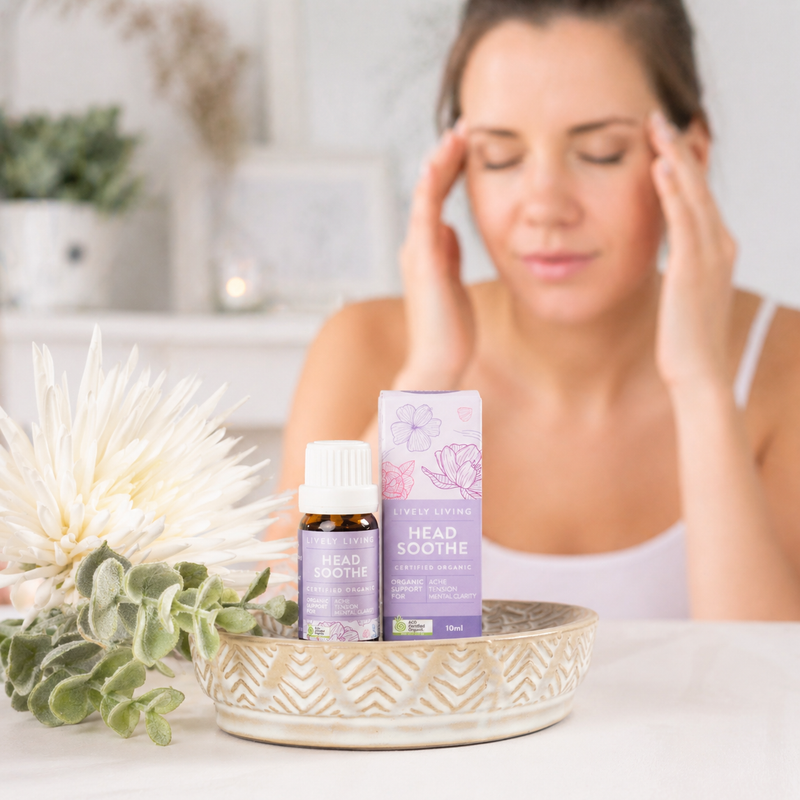 Woman with a headache next to 'Head Soothe' products on a table.