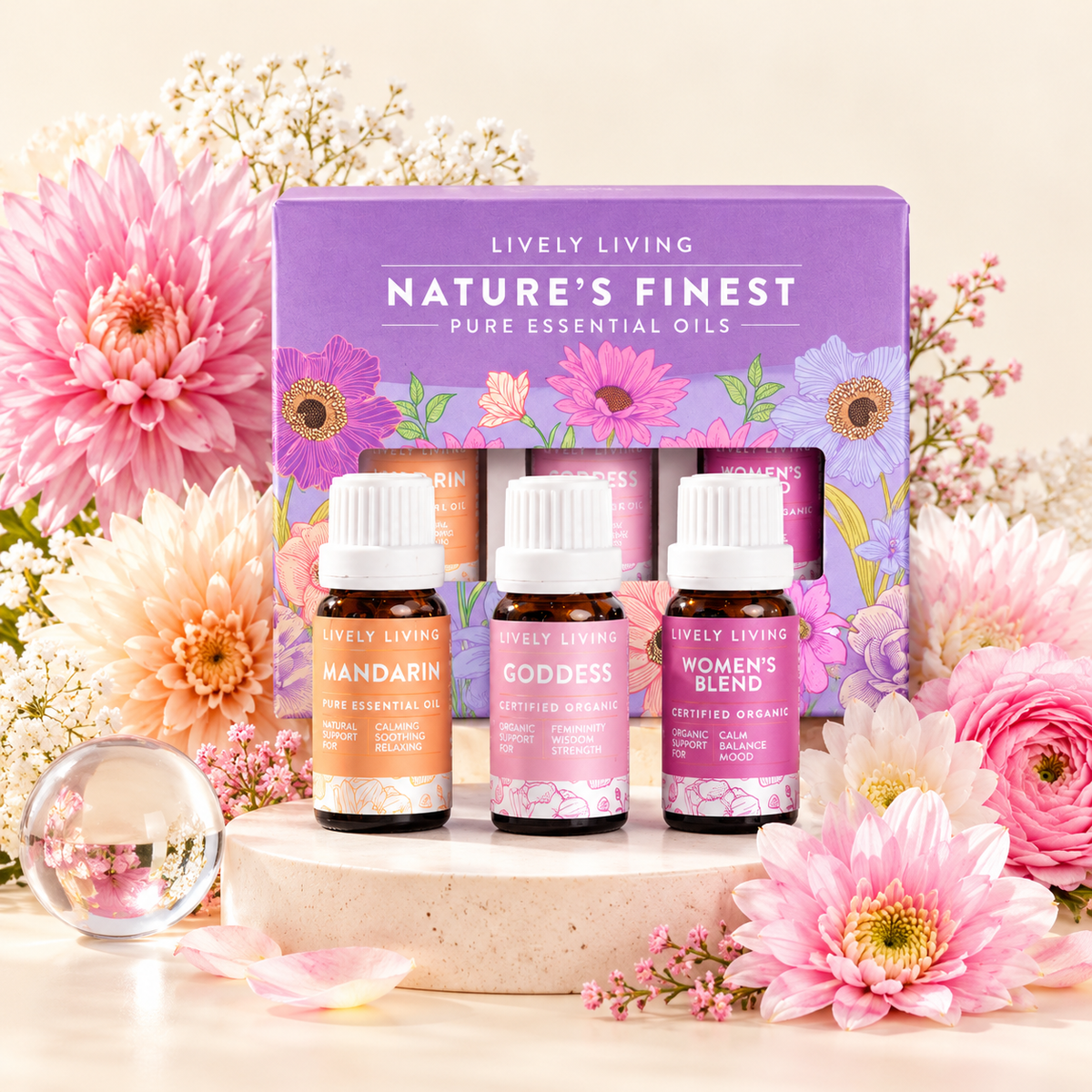 Mandarin, Goddess and Women's Blend essential oils in front of their purple Nature's Finest gift box on a stone plinth with pink blooms