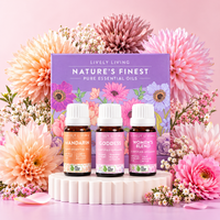 Mandarin, Goddess and Women's Blend essential oils in front of the Lively Living Nature's Finest gift box, surrounded by pink and peach flowers