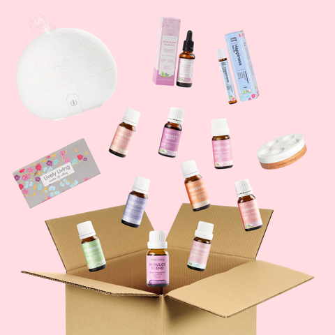 Collection of essential oil bottles and diffusers on a pink background