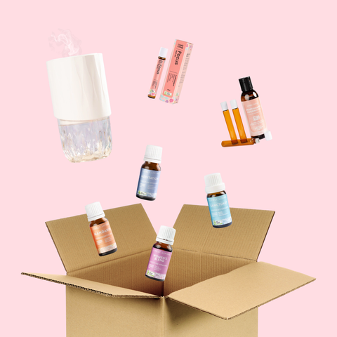 Collection of skincare products including bottles and a lamp on a pink background