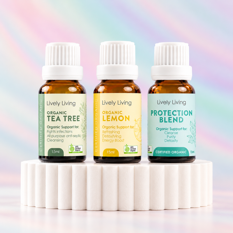 Lively Living Organic Tea Tree, Organic Lemon and Protection Blend 15ml essential oils on a white fluted pedestal against a pastel rainbow background