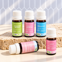 Five Lively Living certified organic 10ml blends, Immune Boost, Calm and Unwind, Breathe, Love and Goddess, on a natural stone slab