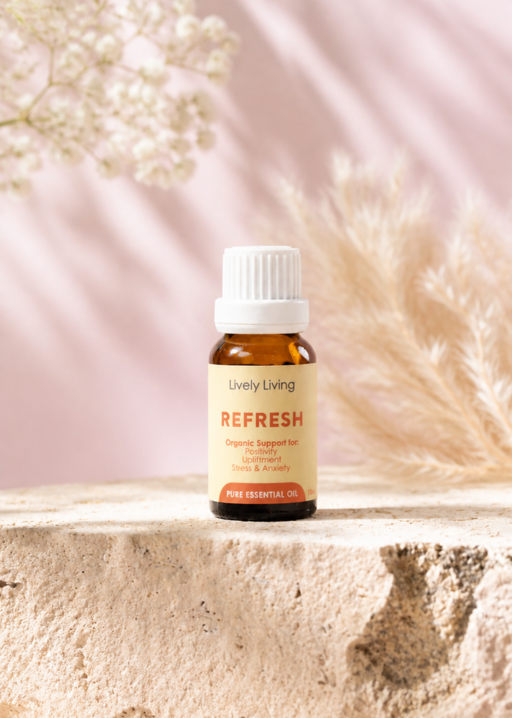 A bottle of Young Living Refresh essential oil on a light surface with a soft pink background and white flowers.