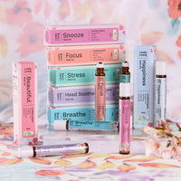 Seven Lively Living roll-ons and boxes including Snooze, Focus, Stress and Happiness on a floral backdrop
