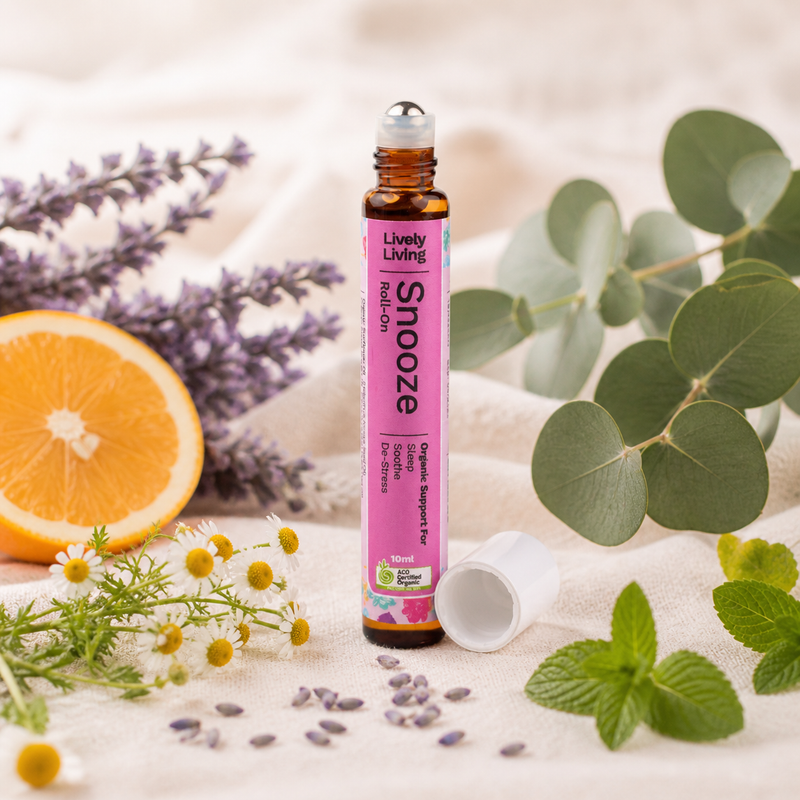 Roll-on bottle labeled 'Snooze' by Lively Living with natural elements like lavender, orange, and eucalyptus on a light background.