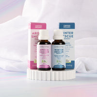 Aroma Snooze Remedy and Winter Rescue Remedy 30ml oils with boxes on a white scalloped pedestal
