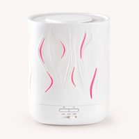 White Aroma-Cloud diffuser with wave cut-outs glowing pink, front view on a white background