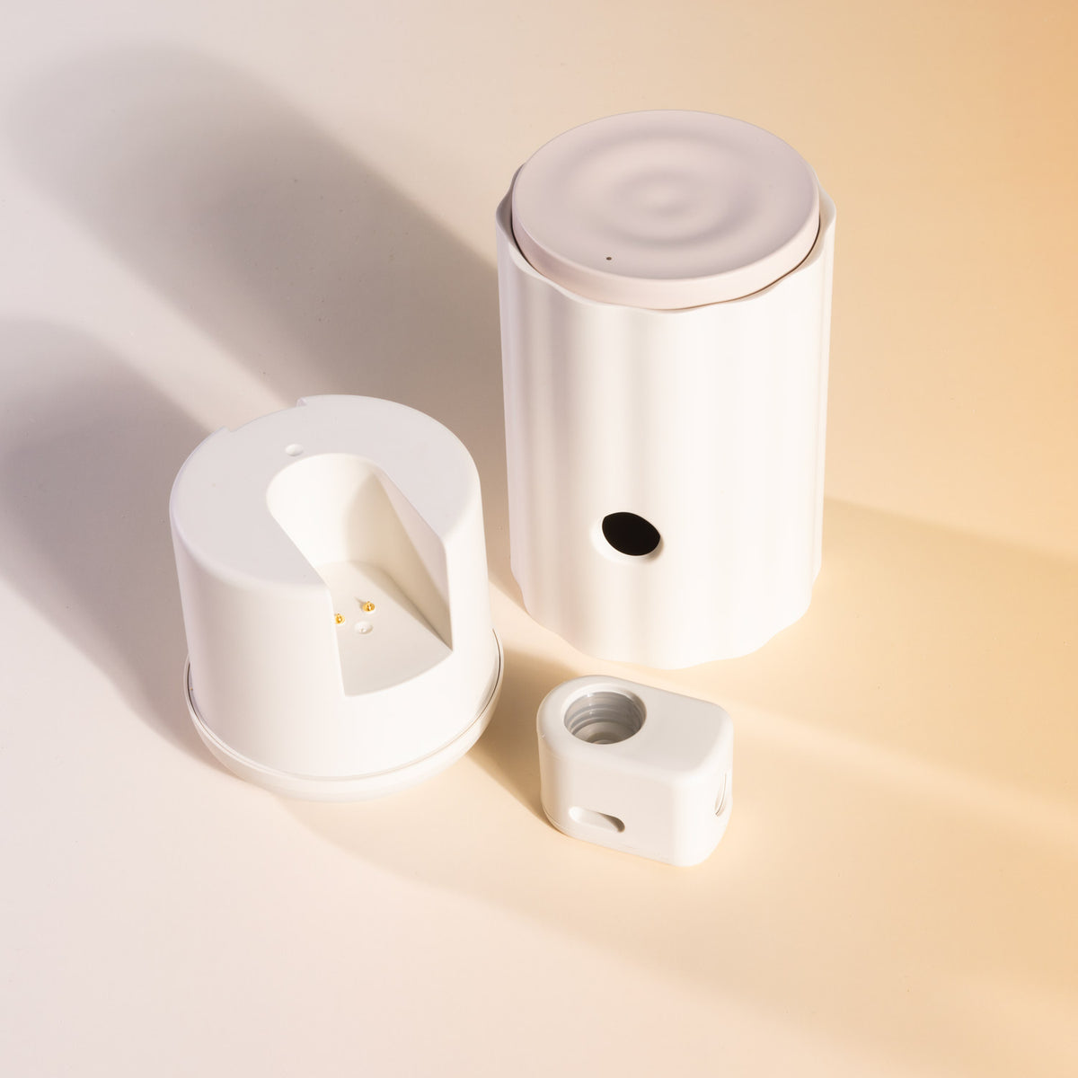 Aroma-Ascension waterless diffuser parts: white diffuser body, base and nebuliser insert on a cream background
