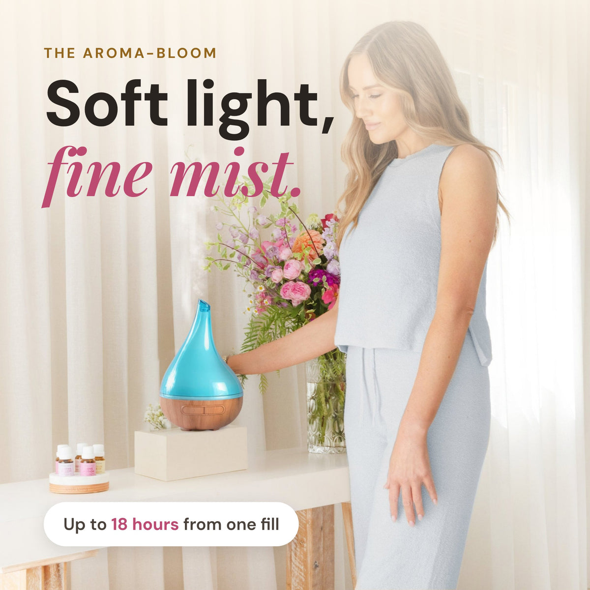 Woman styling the turquoise Aroma-Bloom diffuser in a bright living room, up to 18 hours of mist