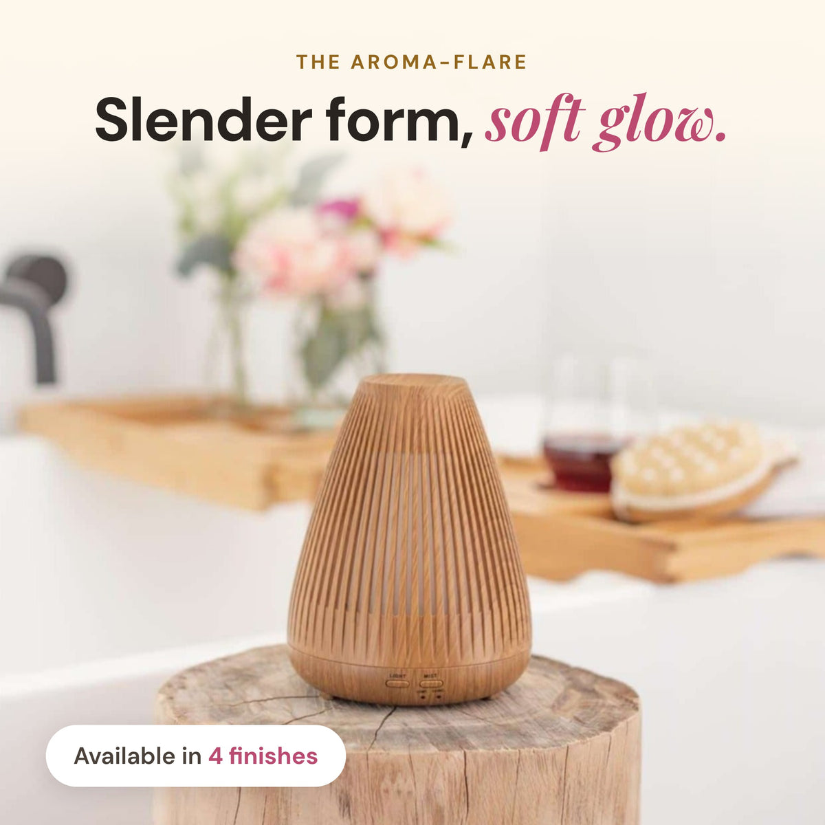 Wood-look Aroma-Flare Diffuser with slatted fins on a timber stump beside a bath tray, headline Slender form, soft glow, available in 4 finishes