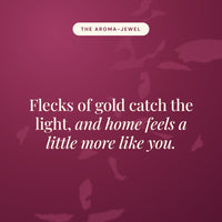 Aroma-Jewel statement card in burgundy reading Flecks of gold catch the light, and home feels a little more like you.