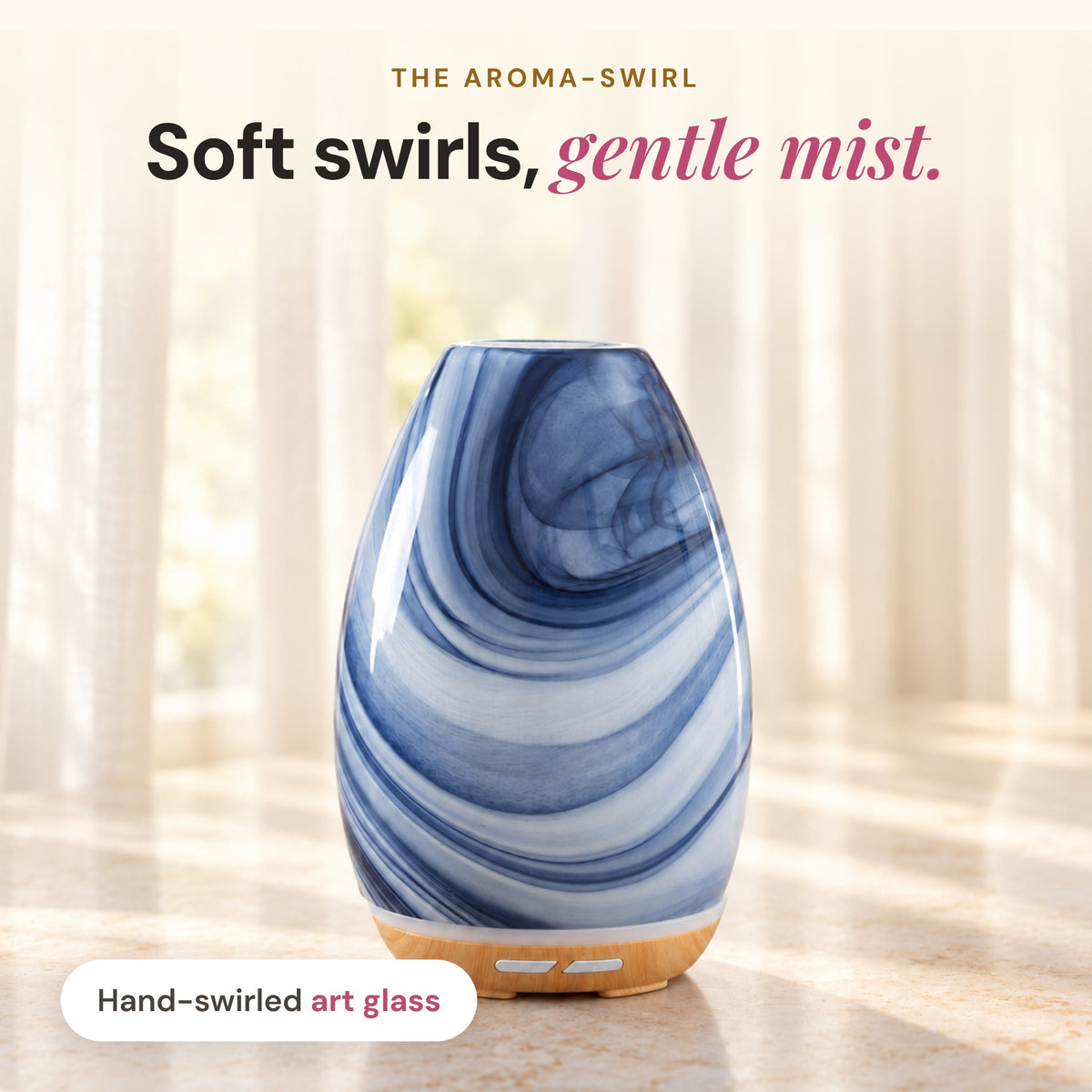 Aroma-Swirl Glass Diffuser in hand-swirled blue and white art glass on a wood-look base in a sunlit room, headline Soft swirls, gentle mist