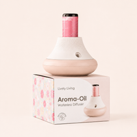 A waterless aroma-oil diffuser by Lively Living in a soft pink and white color scheme, displayed on top of its floral-patterned retail box against a solid pale beige background.