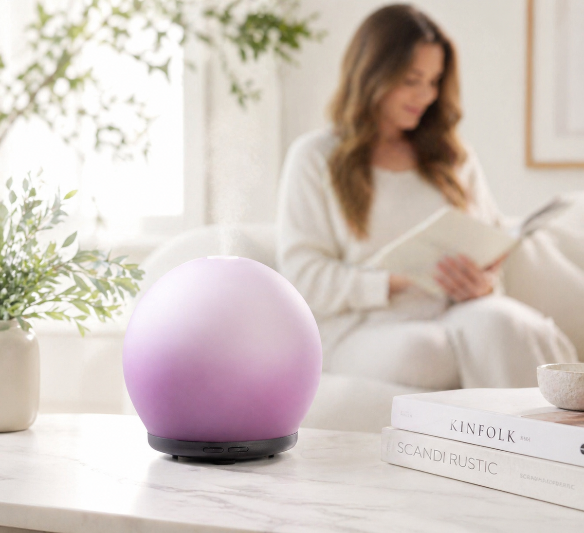 Purple diffuser on a table with a woman reading a book in the background