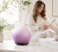 Purple diffuser on a table with a woman reading a book in the background