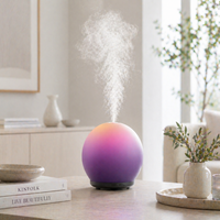 Multicolored diffuser emitting mist on a table with books and decor in the background