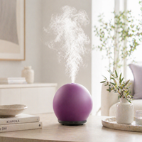 Purple diffuser emitting steam on a table with decor items in the background