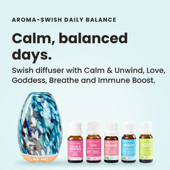 Aroma-Swish Diffuser in hand-shaped blue, teal and white peacock glass on a wood-look base, with five Lively Living certified organic oils from the Daily Balance Collection