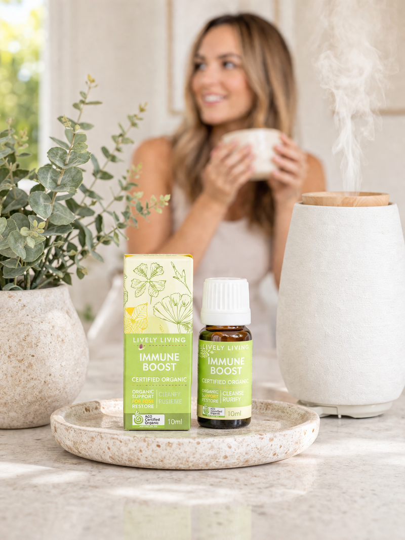 Woman holding a mug with essential oil products on a table