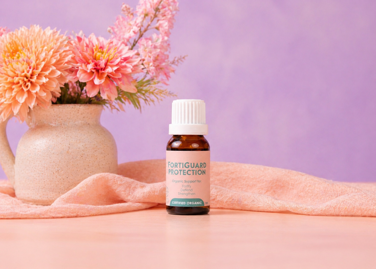 Bottle of Forticuard Protection supplement on a pink surface with flowers in the background