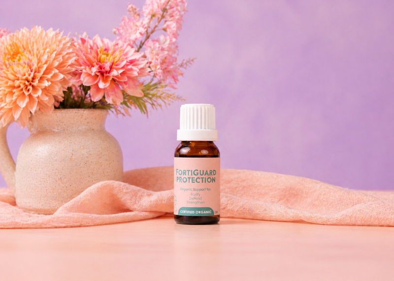 Bottle of Forticuard Protection supplement on a pink surface with flowers in the background