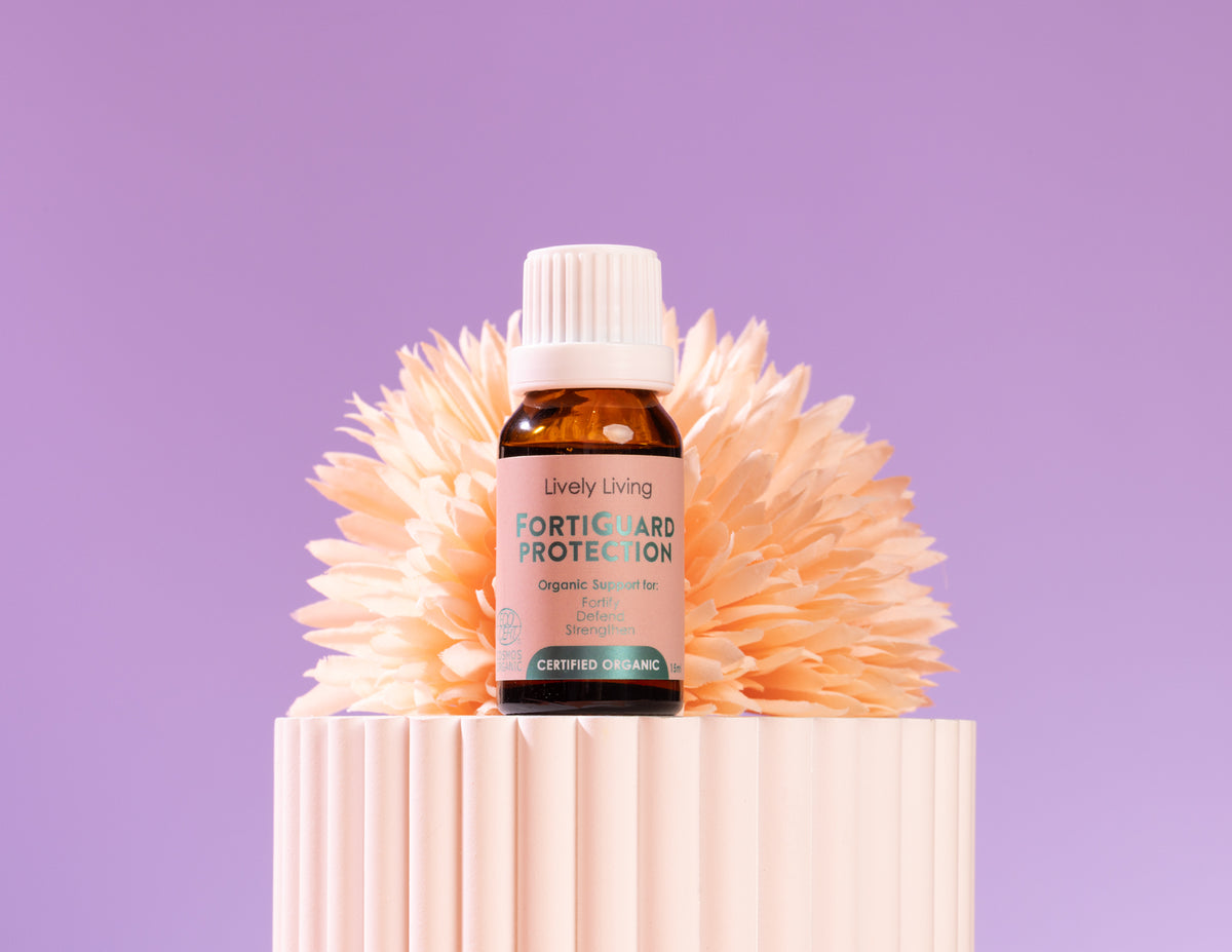 Bottle of Lively Living Forticard Protection on a decorative stand with a purple background