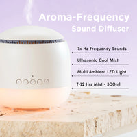 A white circular aroma-frequency sound diffuser with a glowing warm light base, shown on a stone slab with text listing features such as 7x Hz frequency sounds, ultrasonic cool mist, multi ambient LED light, and 7-12 hrs mist - 300ml.