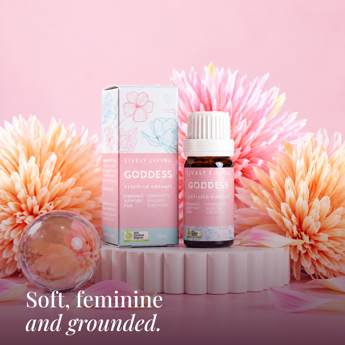 Goddess 10ml oil and box on a white pedestal with peach flowers: soft, feminine and grounded
