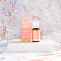 Lively Living essential "grapefruit" oil on a white brick with a lace background