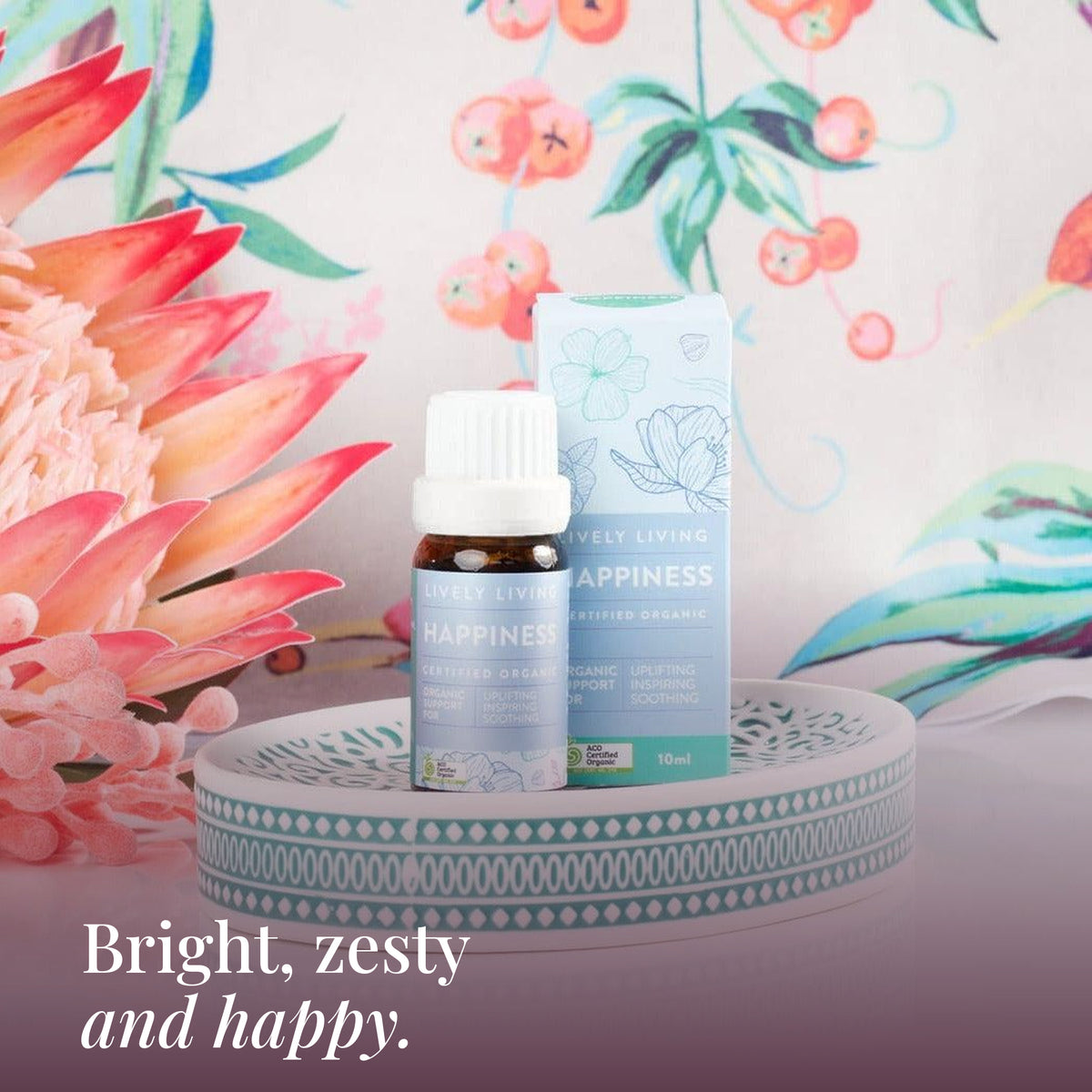 Happiness 10ml oil and box on a teal dish with pink proteas: bright, zesty and happy
