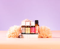 Essential oil bottles with decorative flowers on a gradient background